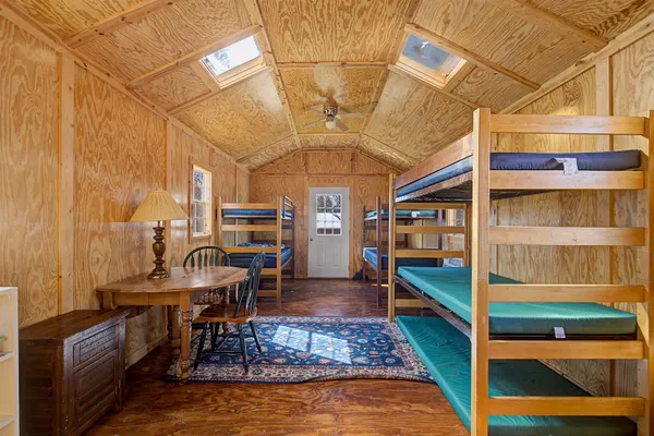 a kitchen with stainless steel appliances granite countertop a refrigerator a sink dishwasher a stove and white cabinets with wooden floor