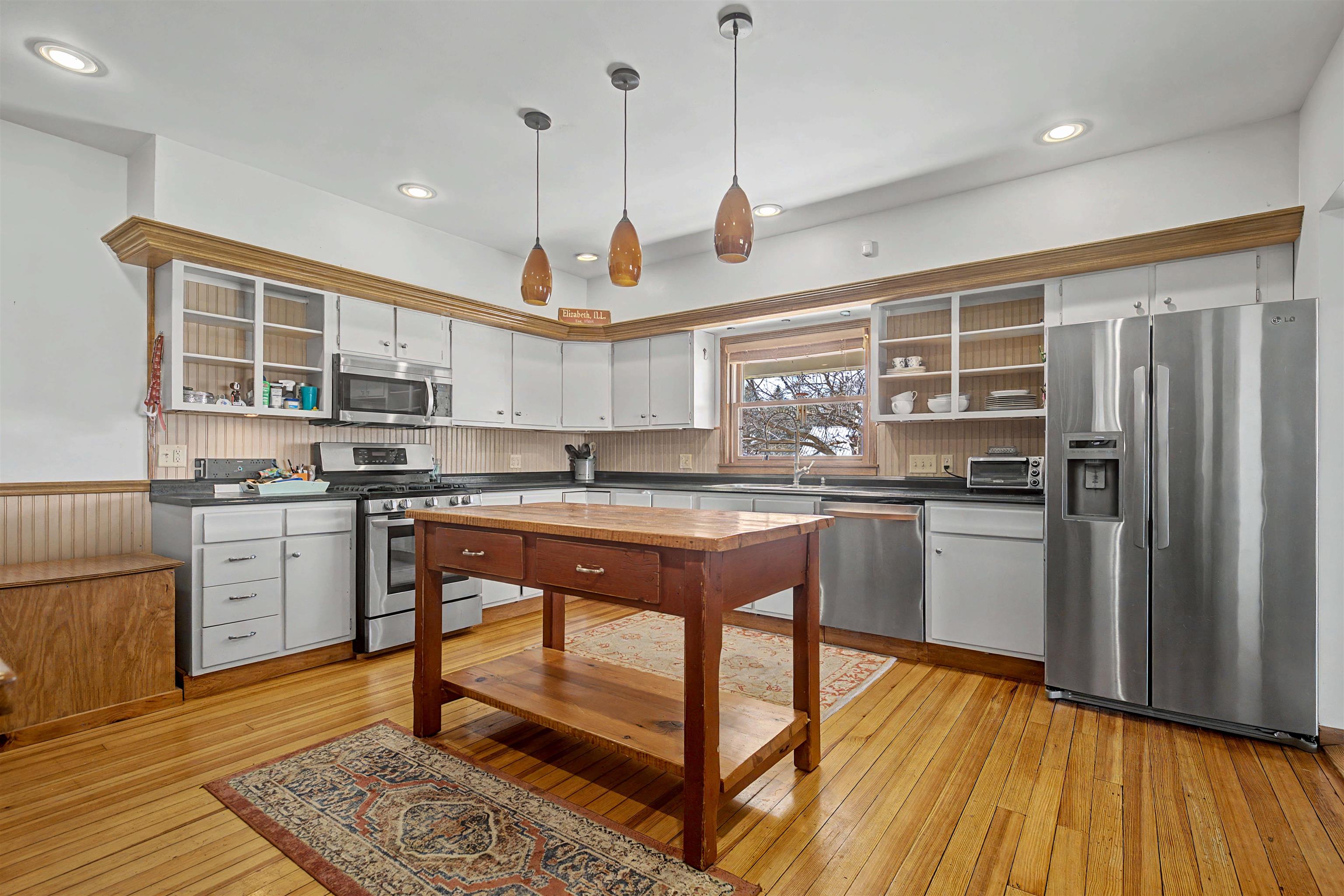 115 Windmill Road Elizabeth, IL 61028 - Photo 43 of 82 a kitchen with stainless steel appliances granite countertop a refrigerator a sink dishwasher a stove and white cabinets with wooden floor
