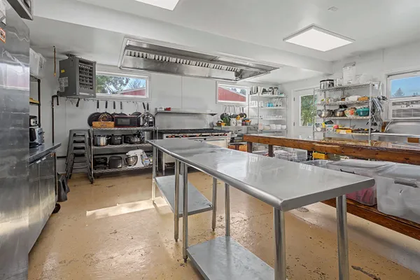 a view of backyard with wooden fence and large trees