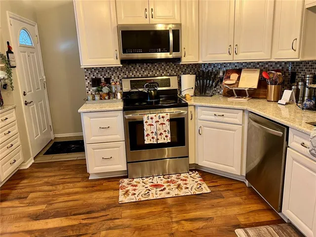 a kitchen with appliances a sink and cabinets