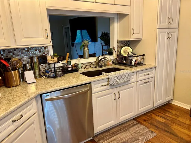 a kitchen with sink a stove and cabinets