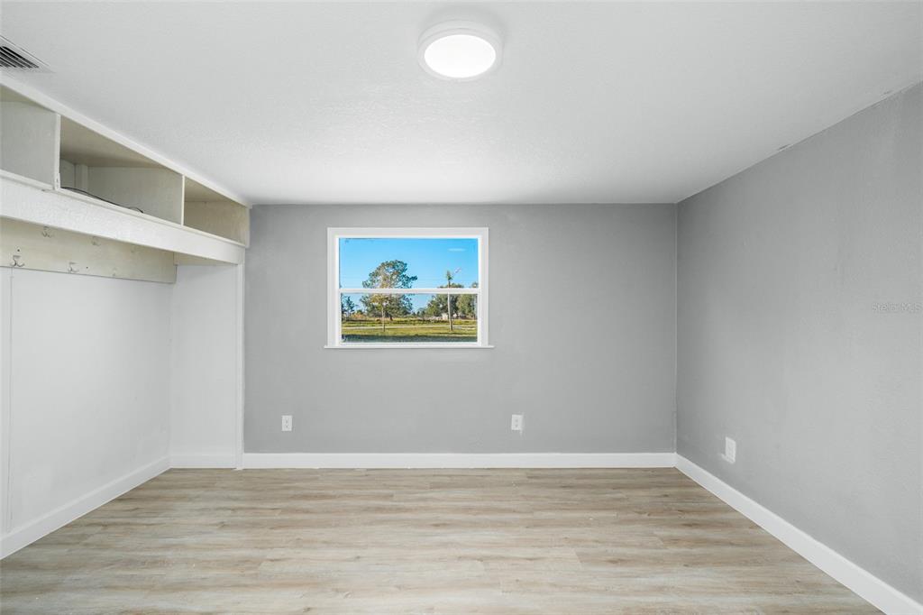 108 Ballard Road Avon Park, FL 33825 - Photo 7 of 12 a view of an empty room with wooden floor and window