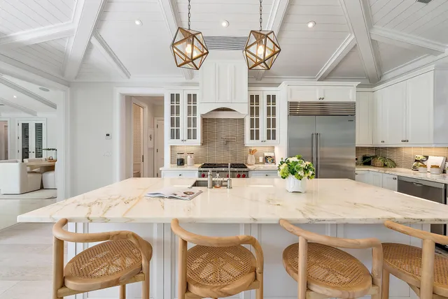 a kitchen with stainless steel appliances kitchen island granite countertop a stove and white cabinets