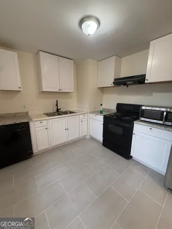 a kitchen with a sink a stove and cabinets