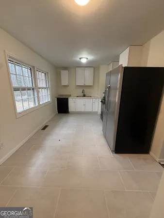 a view of an empty room with a kitchen