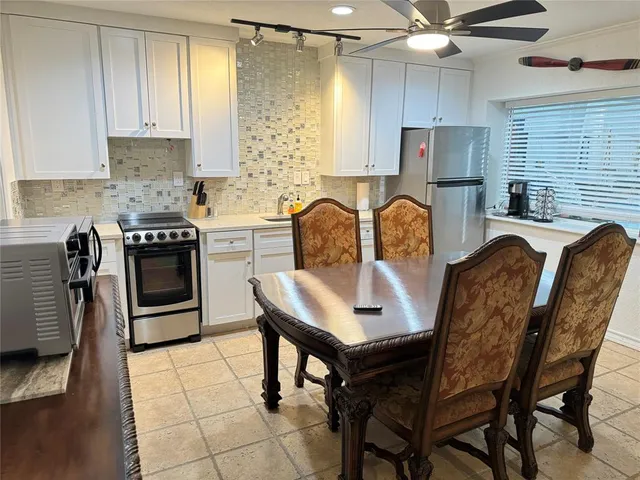 a large bed sitting in a bedroom next to a window and a chandelier