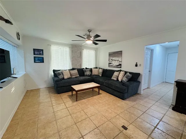 a bed sitting in a bedroom next to a window and a chandelier