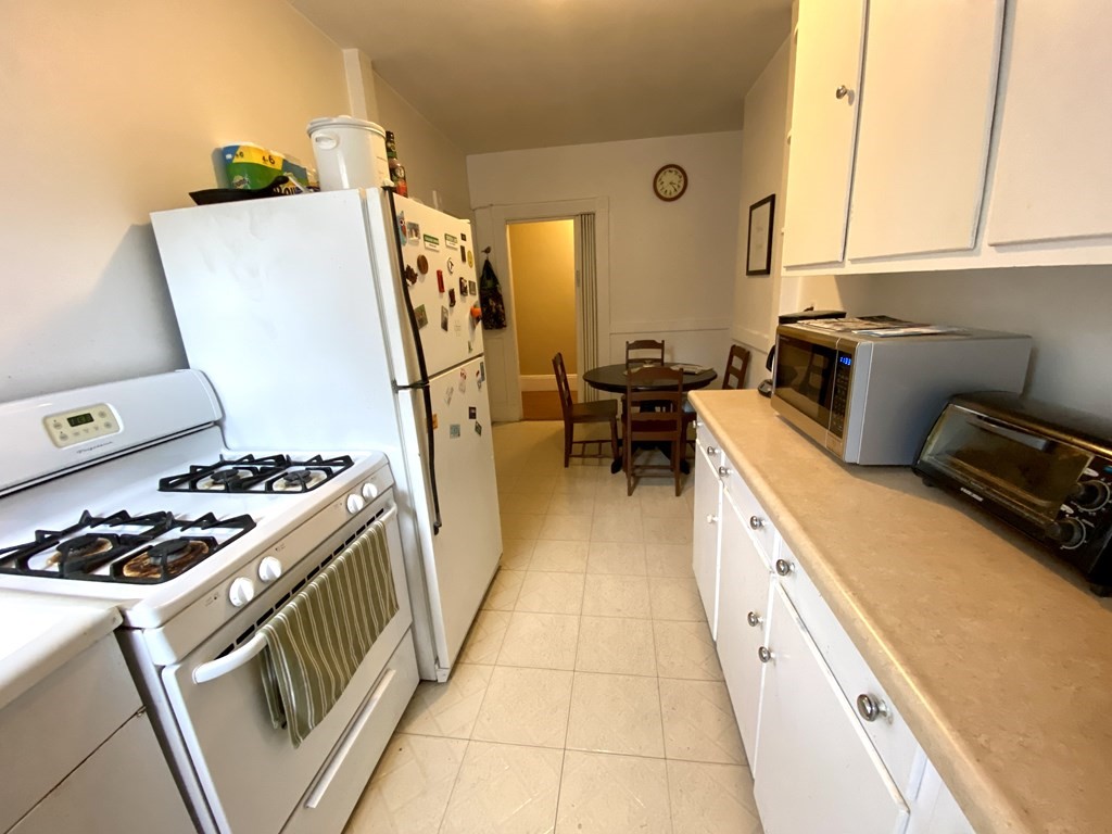15 Parkman Street, Unit 3B Brookline, MA 02446 - Photo 6 of 15 a kitchen with sink a stove and wooden floor