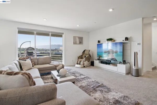 a living room with furniture floor to ceiling window and a flat screen tv
