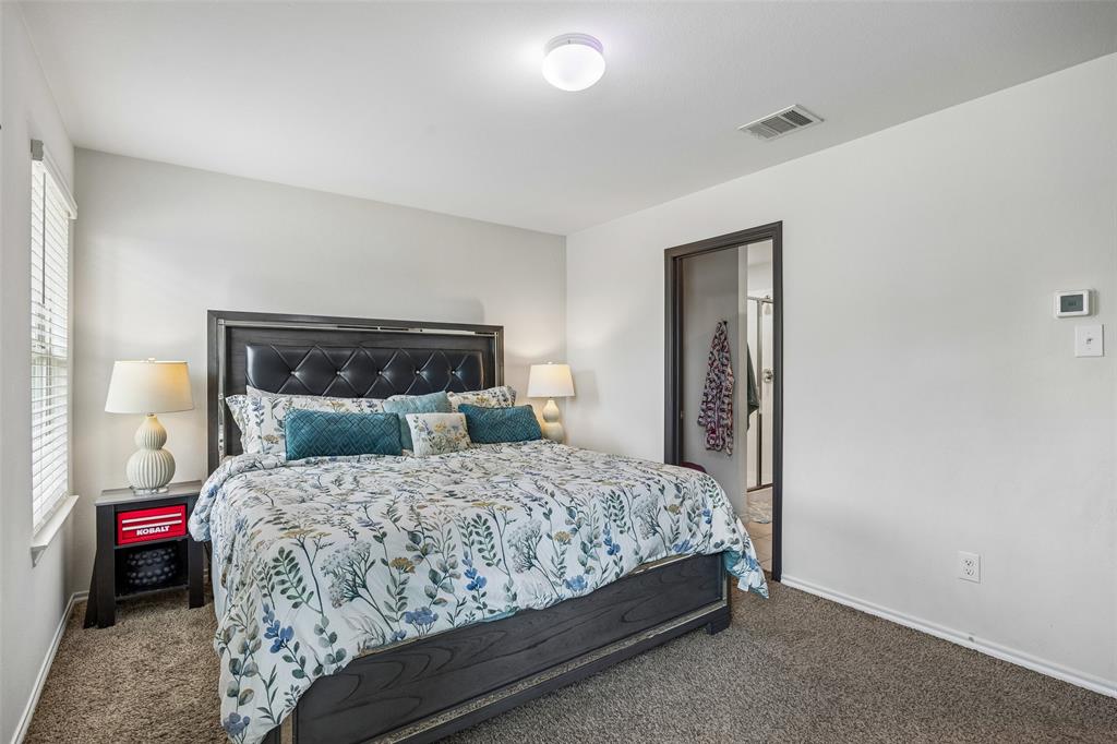 802 Rustic Way Royse City, TX 75189 - Photo 29 of 38 a bedroom with a bed and a lamp