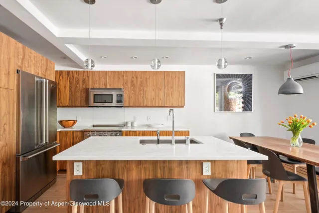 a kitchen with stainless steel appliances a dining table and chairs