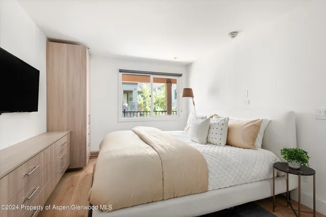 a bedroom with a large bed and a flat tv screen on a dresser