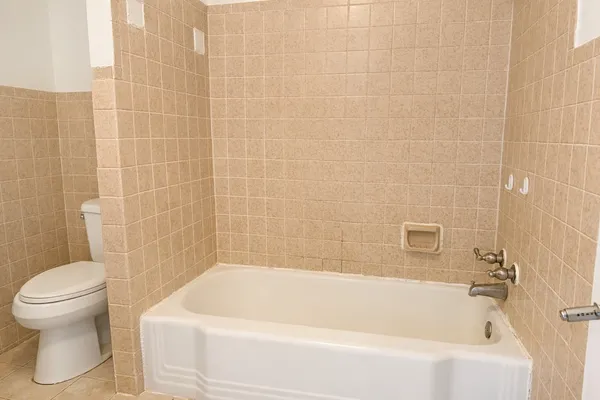 a white bath tub sitting next to a white toilet