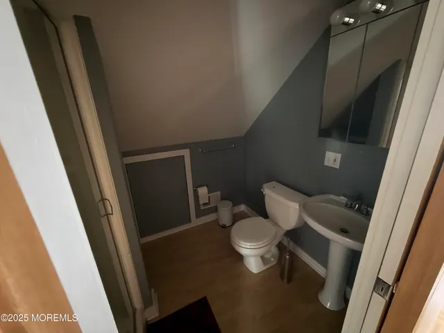 a white toilet sitting next to a sink and vanity