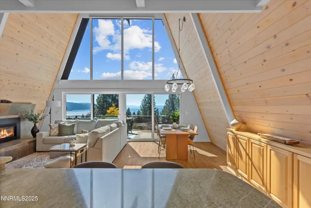 a living room with furniture a rug and a floor to ceiling window