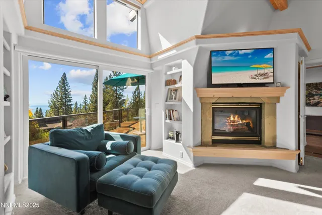 a living room with furniture a floor to ceiling window and a fireplace