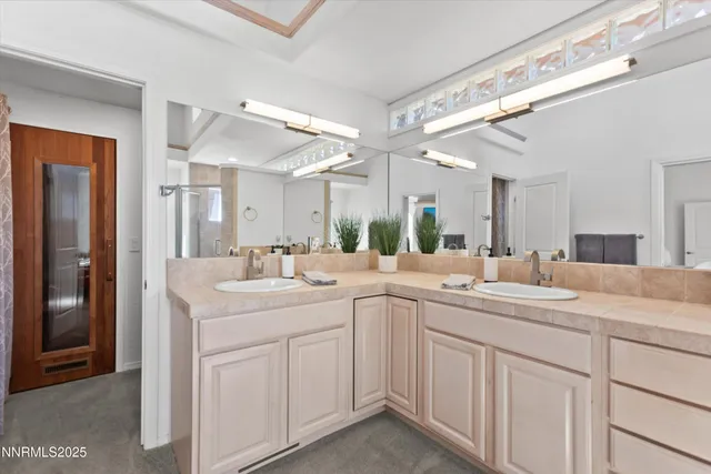 a view of a sink and mirror with cabinets