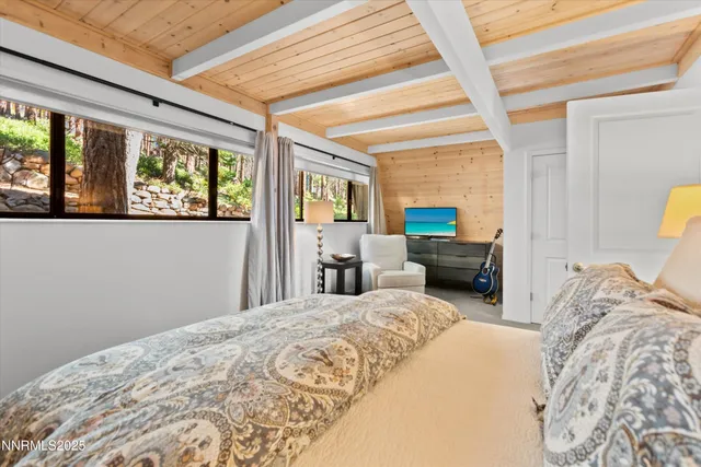 a bedroom with furniture and large windows