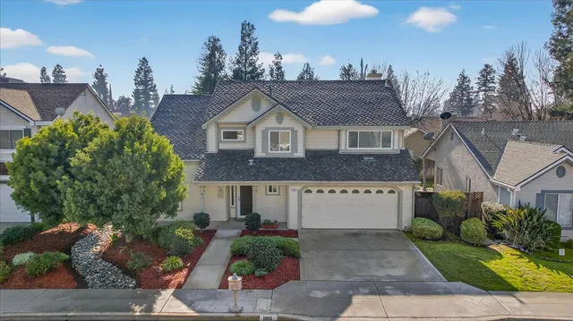 a view of a house with a yard and potted plants