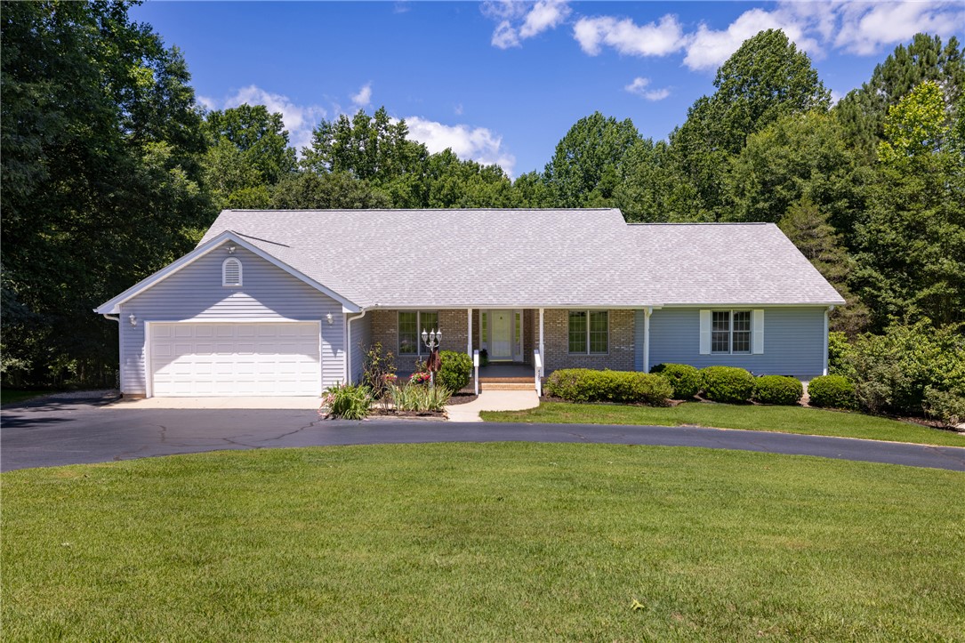 A welcoming front porch and well-maintained landscaping define this inviting ranch-style residence.