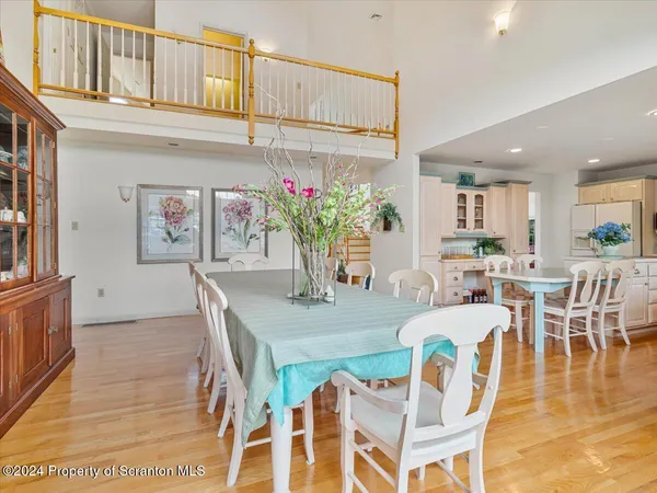 a living room with furniture large windows and wooden floor