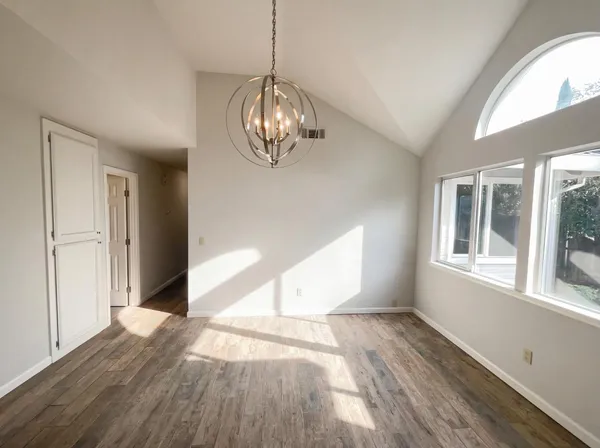 a view of empty room with wooden floor and window