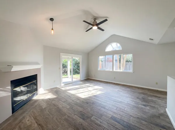 a view of an empty room with a window and fireplace