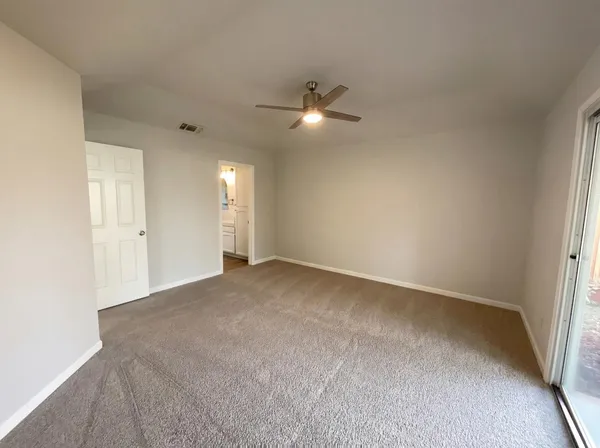 a view of an empty room and a ceiling fan