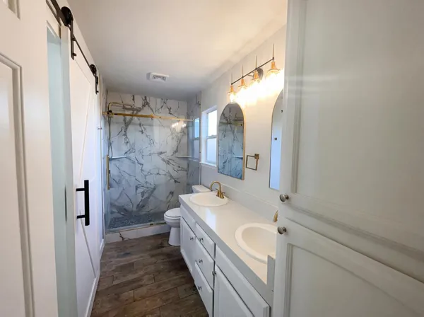 a bathroom with a sink a toilet and shower