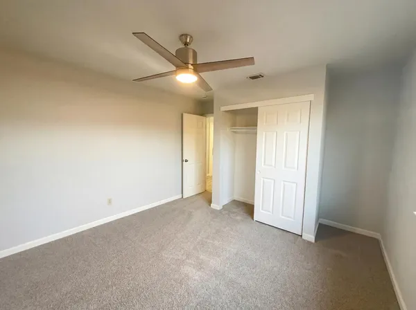 a view of an empty room and a ceiling fan