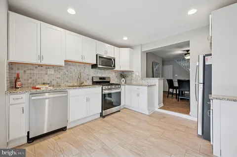 a kitchen with white cabinets and appliances