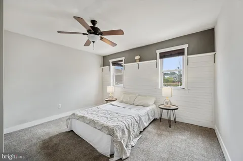 a bedroom with a bed and a ceiling fan