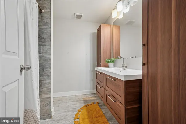 a bathroom with a sink a mirror and a shower