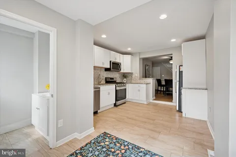 a kitchen with white cabinets and stainless steel appliances