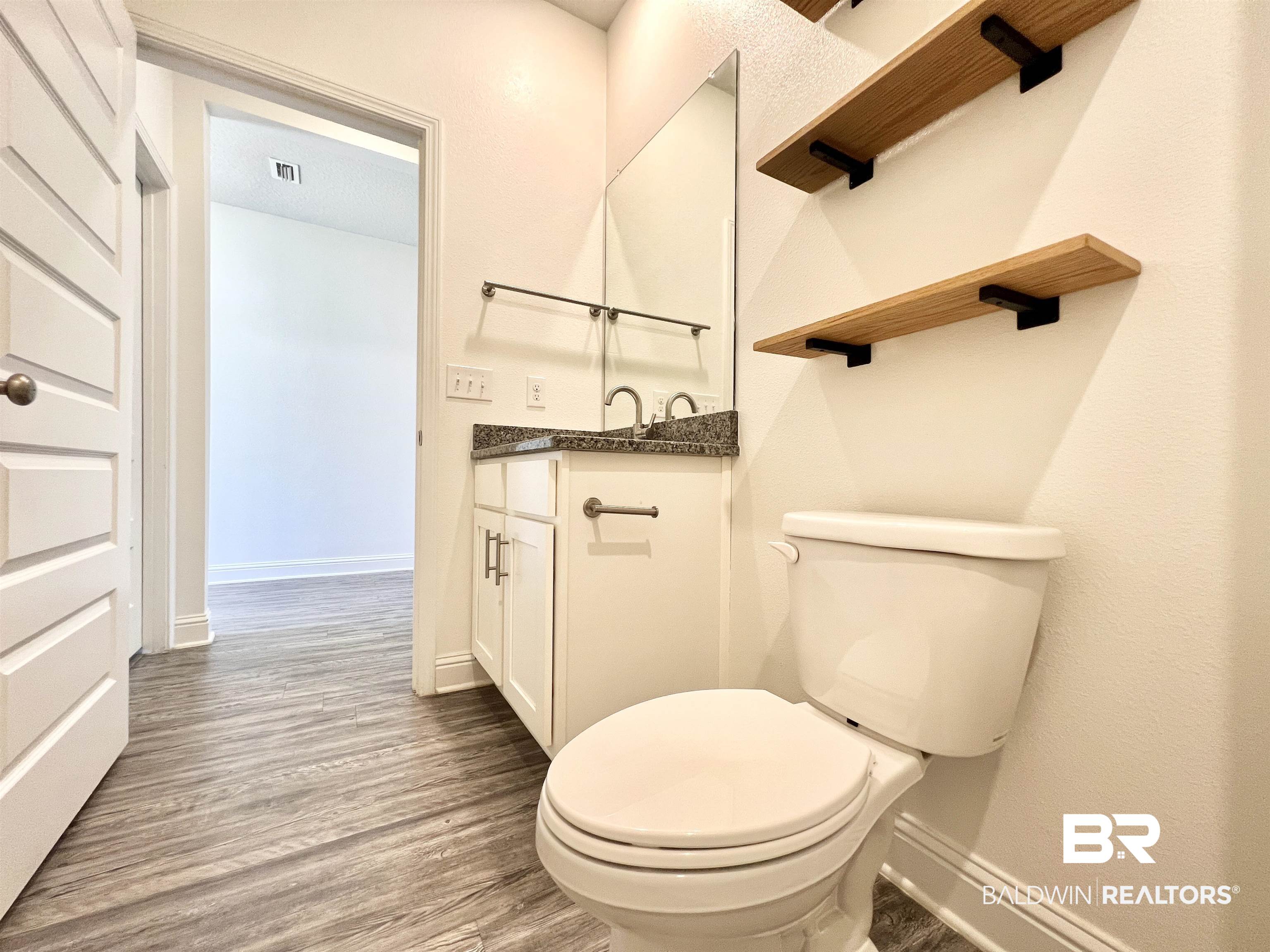 24785 Slater Mill Road Daphne, AL 36526 - Photo 17 of 46 Bathroom with vanity, toilet, and hardwood / wood-style flooring
