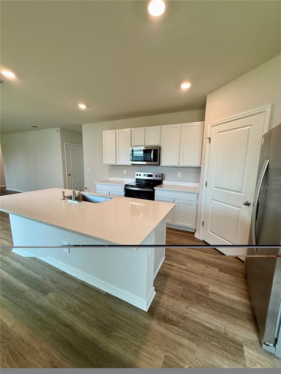 3222 Bitterroot Lane Bradenton, FL 34211 - Photo 12 of 34 a kitchen with kitchen island a refrigerator and a sink