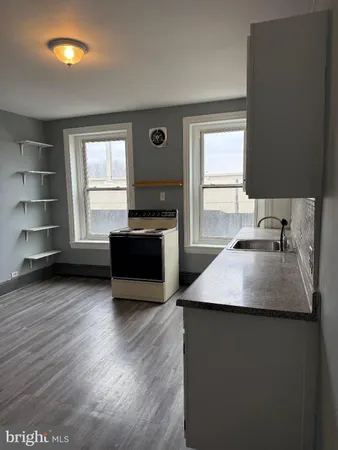a kitchen with kitchen island a sink wooden floor and a window