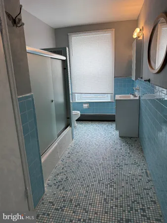 a bathroom with a tub a sink and a mirror