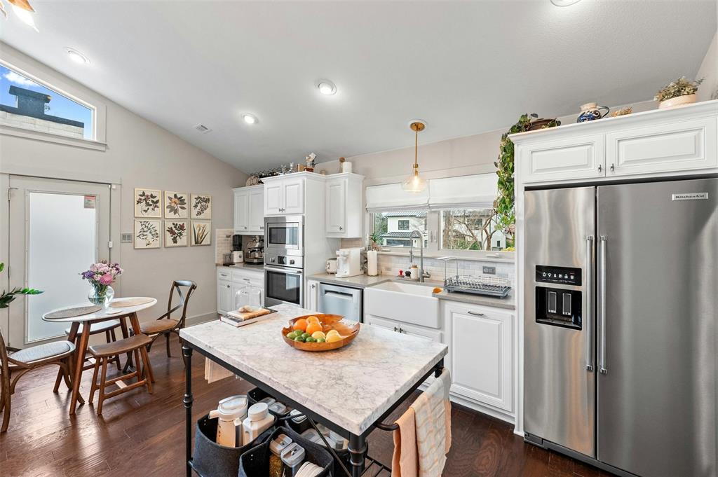 2802 Warren Street, Unit A Austin, TX 78703 - Photo 14 of 29 a kitchen with stainless steel appliances granite countertop a refrigerator a stove a sink dishwasher a dining table and chairs with wooden floor