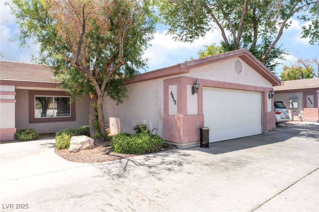 4656 East Desert Inn Road Las Vegas, NV 89121 - Photo 61 of 98 4652 E DI View of front facade with concrete driveway, stucco siding, a garage, and a tiled roof