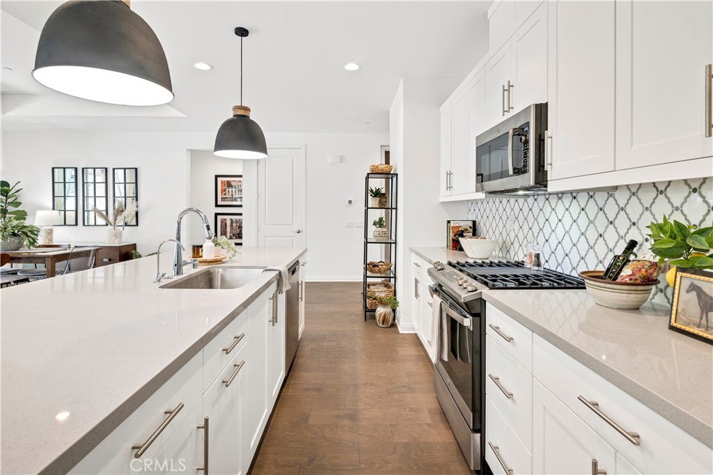 32037 Sedge Way Temecula, CA 92591 - Photo 17 of 61 a large kitchen with stainless steel appliances granite countertop a lot of counter space and wooden floor