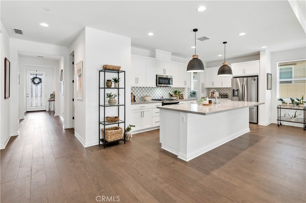 32037 Sedge Way Temecula, CA 92591 - Photo 5 of 61 a large white kitchen with lots of counter space a sink and stainless steel appliances