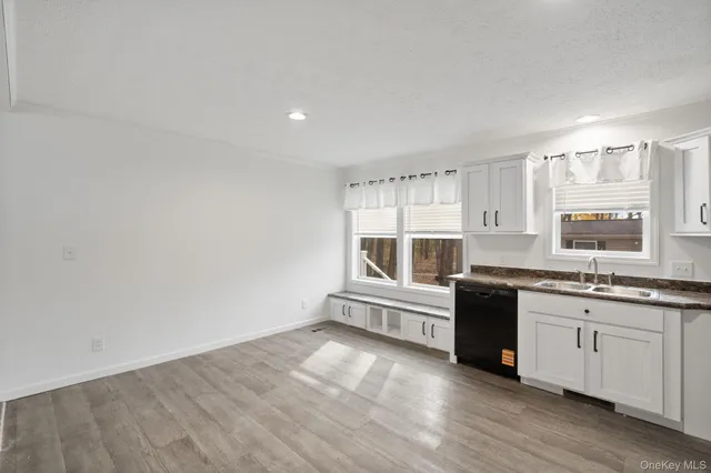 a large kitchen with granite countertop a sink and cabinets