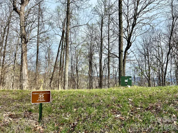 a sign board with tall trees