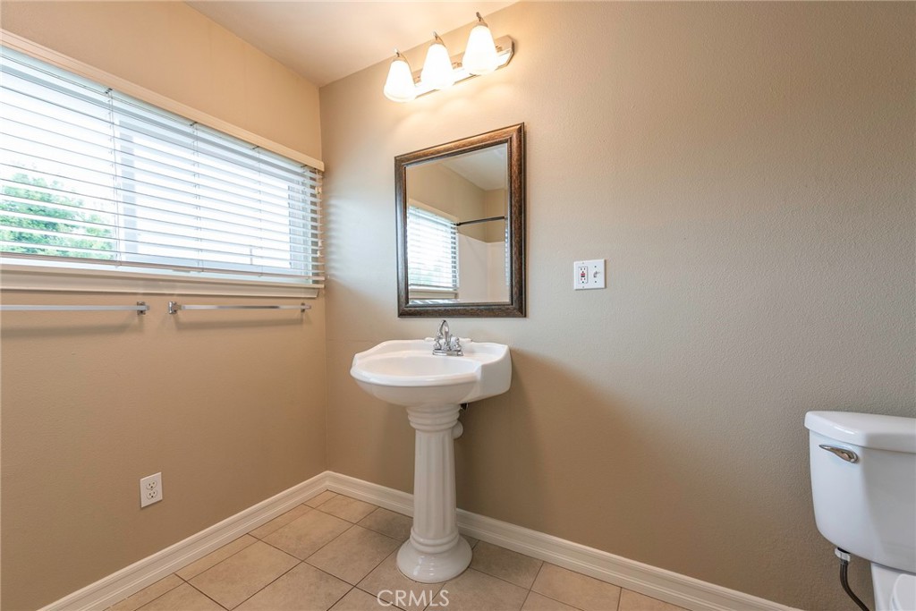4697 Sierra Street Riverside, CA 92504 - Photo 32 of 51 a bathroom with a sink a mirror and a window