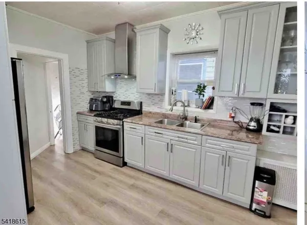 a kitchen with granite countertop a sink cabinets stainless steel appliances and a window