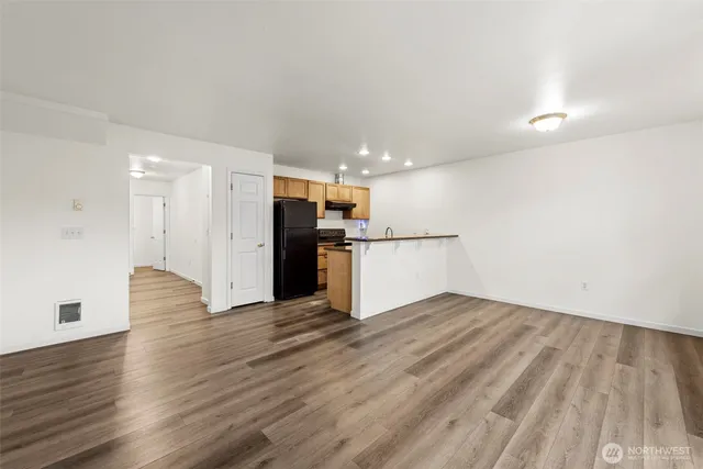 a view of a kitchen with wooden floor and electronic appliances