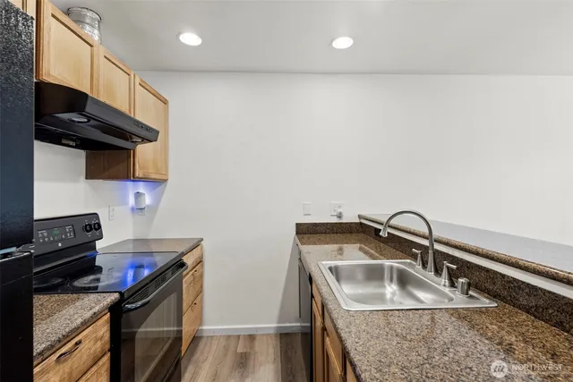 a kitchen with stainless steel appliances granite countertop a sink stove and refrigerator