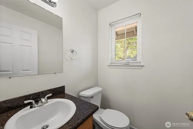 a bathroom with a sink toilet and a mirror