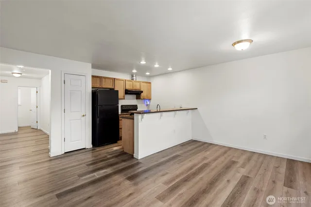 a view of kitchen with wooden floor and electronic appliances